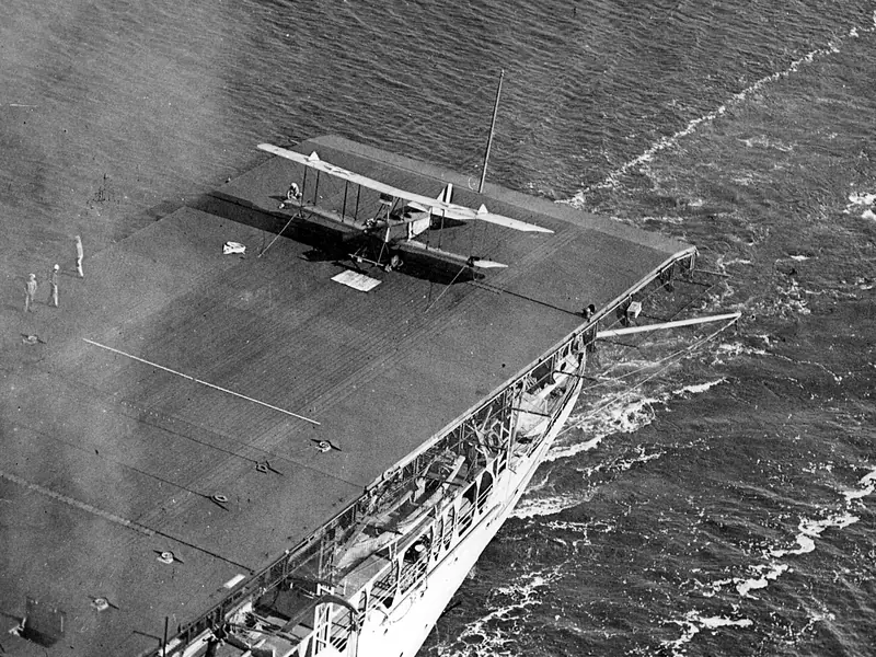 A biplane on the wooden flight deck of USS Langley in 1923