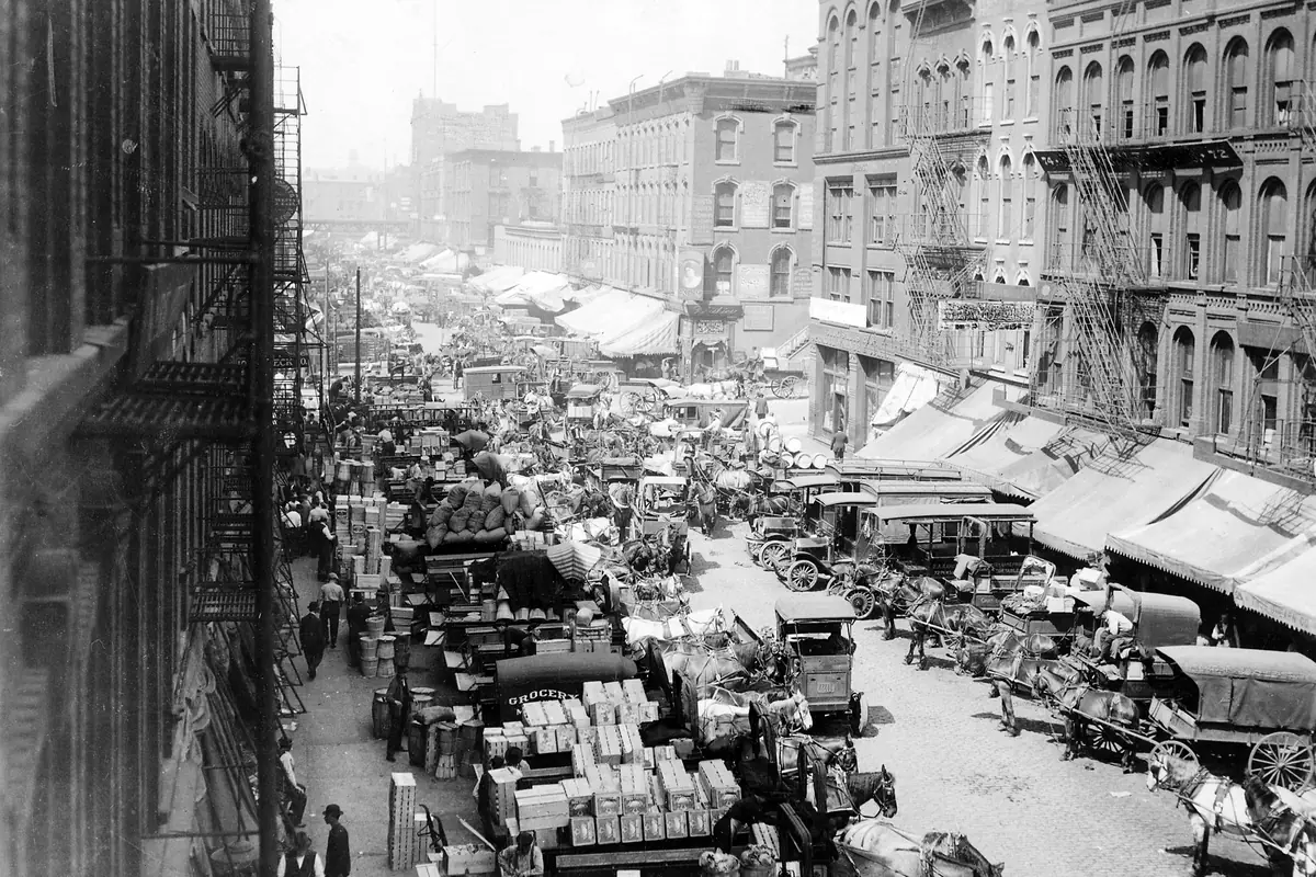 Horse-drawn wagons and early motor trucks crowd a Chicago produce street in 1915