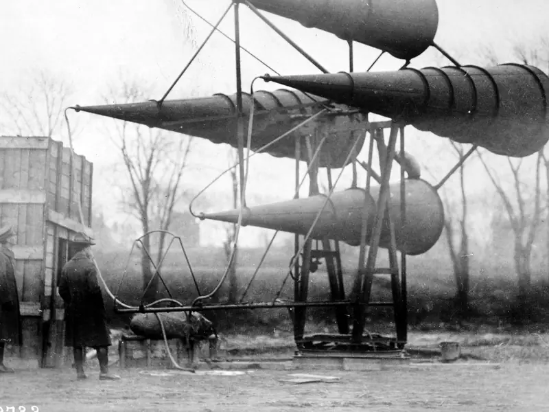 A long-horn acoustic anti-aircraft listening set with two men beside it in 1919